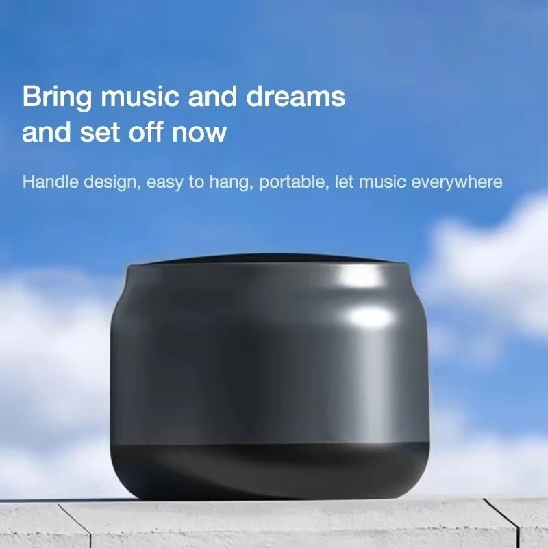 Portable black wireless speaker with handle design against blue sky background
